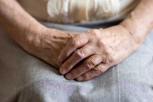 Older adults share a meal and conversation at a bright assisted living dining table.
